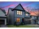 Striking two-story home with a modern exterior, dark trim, a well-manicured lawn, and a two-car garage at 3907 Plainview Rd, Charlotte, NC 28208