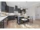 Sleek kitchen featuring dark cabinets, stainless steel appliances, and a functional island with seating at 3907 Plainview Rd, Charlotte, NC 28208