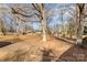 Large, leaf-covered backyard with mature trees and plenty of space for recreation at 4000 Elizabeth St, Hickory, NC 28601