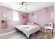 Comfortable bedroom featuring laminate floors, a ceiling fan, and bright, lavender-colored walls at 4000 Elizabeth St, Hickory, NC 28601