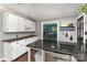 Functional kitchen with black countertops, white cabinetry, and an open view to the dining area at 4000 Elizabeth St, Hickory, NC 28601