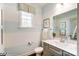 Stylish bathroom with a striped wall, framed mirror, and gray vanity, creating a serene space at 4230 Black Ct # 235, Harrisburg, NC 28075