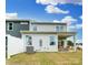 A view of the property's rear elevation, featuring a fenced in yard, patio area, and an AC unit sitting on the grass at 4230 Black Ct # 235, Harrisburg, NC 28075