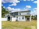 Wide rear view of the property showcasing the patio area, fenced in yard, and an AC unit sitting on the grass at 4230 Black Ct # 235, Harrisburg, NC 28075