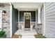 Inviting front porch with stone pillars and craftsman style front door with decorative address plaque at 4236 Black Ct # 234, Harrisburg, NC 28075