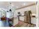 Bright kitchen features stainless appliances, granite counters, an island with seating, and wood-look floors at 4236 Black Ct # 234, Harrisburg, NC 28075