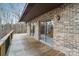 Spacious deck featuring a brick exterior, outdoor lighting, wooden railing, and sliding glass doors at 5580 Crepe Myrtle Rd, York, SC 29745