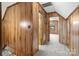 Hallway with wood paneling leading to several rooms with carpeted floors at 5580 Crepe Myrtle Rd, York, SC 29745