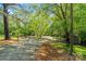 Long paved driveway with a wooden fence and a carport in a lush, wooded setting at 5580 Crepe Myrtle Rd, York, SC 29745