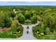 Aerial view of a landscaped neighborhood entrance featuring a roundabout, trimmed greenery, and lush surrounding trees at 6601 Harbor Oaks Dr, Denver, NC 28037