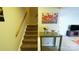 Carpeted staircase with wooden handrail and nearby table displaying floral art adds character to the home's interior at 7005 Stonington Ln, Charlotte, NC 28227