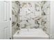 Bathroom showcases marble-look tile surround and a tub with a shower at 711 E John St, Matthews, NC 28105