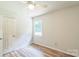 An airy bedroom features wood-look flooring, a window and white doors at 711 E John St, Matthews, NC 28105