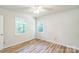 A bedroom features two windows, wood-look flooring and neutral paint at 711 E John St, Matthews, NC 28105