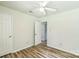 A bedroom with light walls, white door, wood-look floors and ceiling fan at 711 E John St, Matthews, NC 28105
