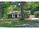 Cozy home with a mature tree in the front yard and partial fencing at 711 E John St, Matthews, NC 28105