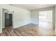 A bright living room has wood-look floors and neutral paint at 711 E John St, Matthews, NC 28105