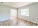 A living room has wood-look floors, neutral walls and a picture window at 711 E John St, Matthews, NC 28105