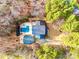 A stunning aerial view reveals a backyard pool, surrounded by mature trees and lush landscaping at 8384 Blades Trl, Denver, NC 28037