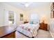 Sunny bedroom featuring a large window with white curtains, a ceiling fan, and carpet floors at 8384 Blades Trl, Denver, NC 28037