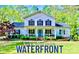 Charming waterfront home with a covered front porch, beautiful landscaping, and blue accents at 8384 Blades Trl, Denver, NC 28037