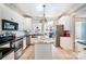Kitchen features white cabinets, granite countertops, stainless steel appliances, and tile floor with a center island at 8384 Blades Trl, Denver, NC 28037