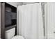 Clean bathroom featuring a dark shelving unit, toilet, and shower with a white curtain at 9160 Exbury Ct, Charlotte, NC 28269