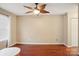 Spacious bedroom with a ceiling fan, warm paint, and hardwood flooring at 9160 Exbury Ct, Charlotte, NC 28269