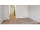 Bedroom highlighting neutral walls, carpet flooring, and hallway access at 9160 Exbury Ct, Charlotte, NC 28269
