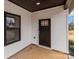 A modern-style front door with white trim, complementing the exterior's white siding and black framed window at 923 Cedar St, Salisbury, NC 28144