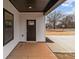 View of front door with black trim with concrete porch and white siding on the exterior at 923 Cedar St, Salisbury, NC 28144