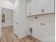 Laundry room has overhead cabinets, utility connections, and wood-look floors at 923 Cedar St, Salisbury, NC 28144
