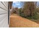 Side view of a home's exterior showing white siding and some grass and trees at 923 Cedar St, Salisbury, NC 28144
