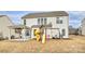 Expansive backyard with a covered patio, playset, swing set, and well-maintained lawn, ideal for recreation at 1035 Ivey Ct, Fort Mill, SC 29707