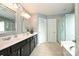 Bright bathroom featuring double sinks, a glass-enclosed shower, and a soaking tub, perfect for relaxation and modern living at 1035 Ivey Ct, Fort Mill, SC 29707