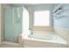 Bright bathroom featuring a soaking tub, a glass-enclosed shower, and a window, perfect for relaxation and modern living at 1035 Ivey Ct, Fort Mill, SC 29707