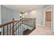 Upper hallway with decorative wallpaper, wood railing, and carpet flooring at 1035 Ivey Ct, Fort Mill, SC 29707