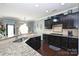 Well-equipped kitchen featuring granite countertops, stainless steel sink, and dark cabinetry at 1035 Ivey Ct, Fort Mill, SC 29707