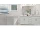 Bright bathroom featuring double vanity, white cabinets, and soaking tub with sleek, modern fixtures at 108 Sari St, Troutman, NC 28166