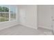 Bright, carpeted bedroom with multiple windows, offering ample natural light and serene views at 108 Sari St, Troutman, NC 28166