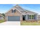 Charming home featuring stone accents, a two-car garage, and a well-manicured lawn, creating an inviting curb appeal at 108 Sari St, Troutman, NC 28166