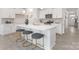 Modern kitchen featuring a large island with seating, white cabinets, and stainless steel appliances, perfect for entertaining at 108 Sari St, Troutman, NC 28166