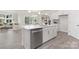 Open-concept kitchen featuring an island with a dishwasher, stainless appliances, and easy access to the living area at 108 Sari St, Troutman, NC 28166
