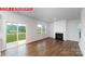 Bright living room with a cozy fireplace, sliding glass door to backyard, and hardwood flooring at 11204 Cardinal Creek Ave, Charlotte, NC 28215