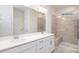 Bright bathroom featuring double sink vanity and large glass-enclosed shower with a bench at 119 Noah Ln, Troutman, NC 28166