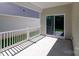 A covered porch with concrete flooring and white railing at 119 Noah Ln, Troutman, NC 28166