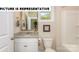 Bright bathroom featuring a granite countertop, white vanity, and a shower with a white surround at 121 Noah Ln, Troutman, NC 28166