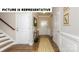 Inviting entryway with hardwood floors, decorative rug, and classic white wainscoting at 121 Noah Ln, Troutman, NC 28166