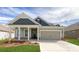 Charming single-Gathering home featuring a welcoming front porch, stone accents, and a two-car garage at 121 Noah Ln, Troutman, NC 28166