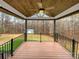 Large covered back deck with stained wood flooring, ceiling fan and railing overlooking backyard at 121 Purple Finch Ln, Mooresville, NC 28117